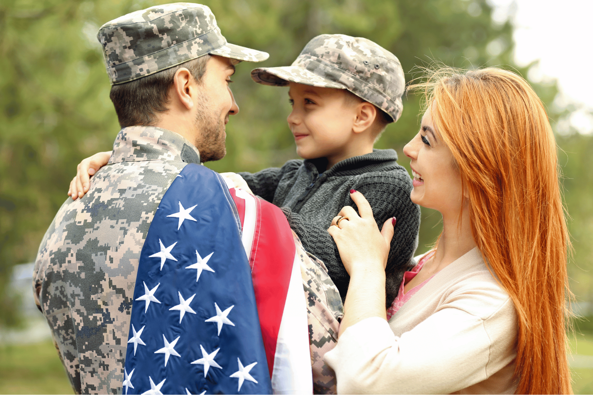 Military family with American flag - servicemember, spouse, and child
