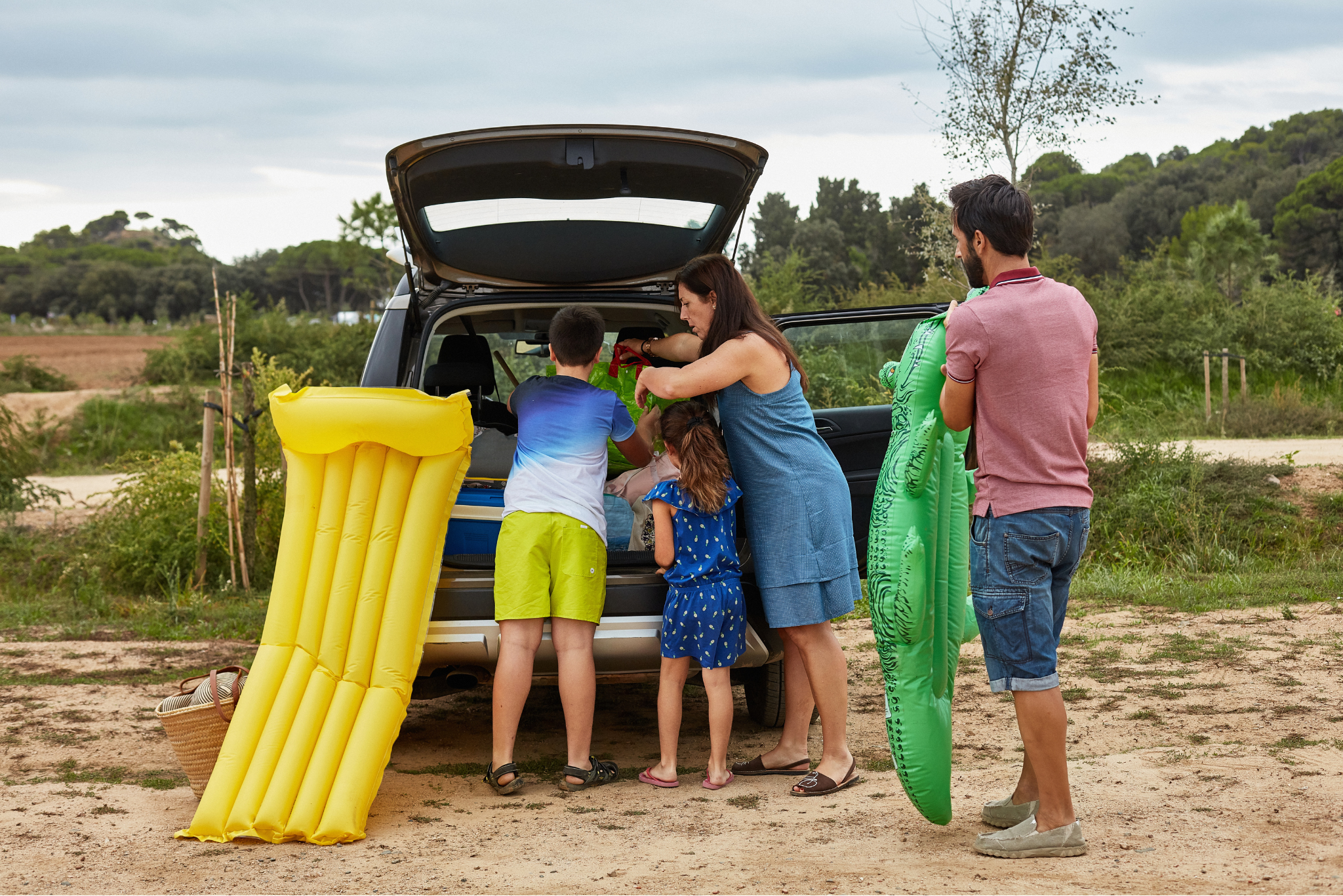 Happy family celebrating with their safe SUV overlooking the Emerald Coast