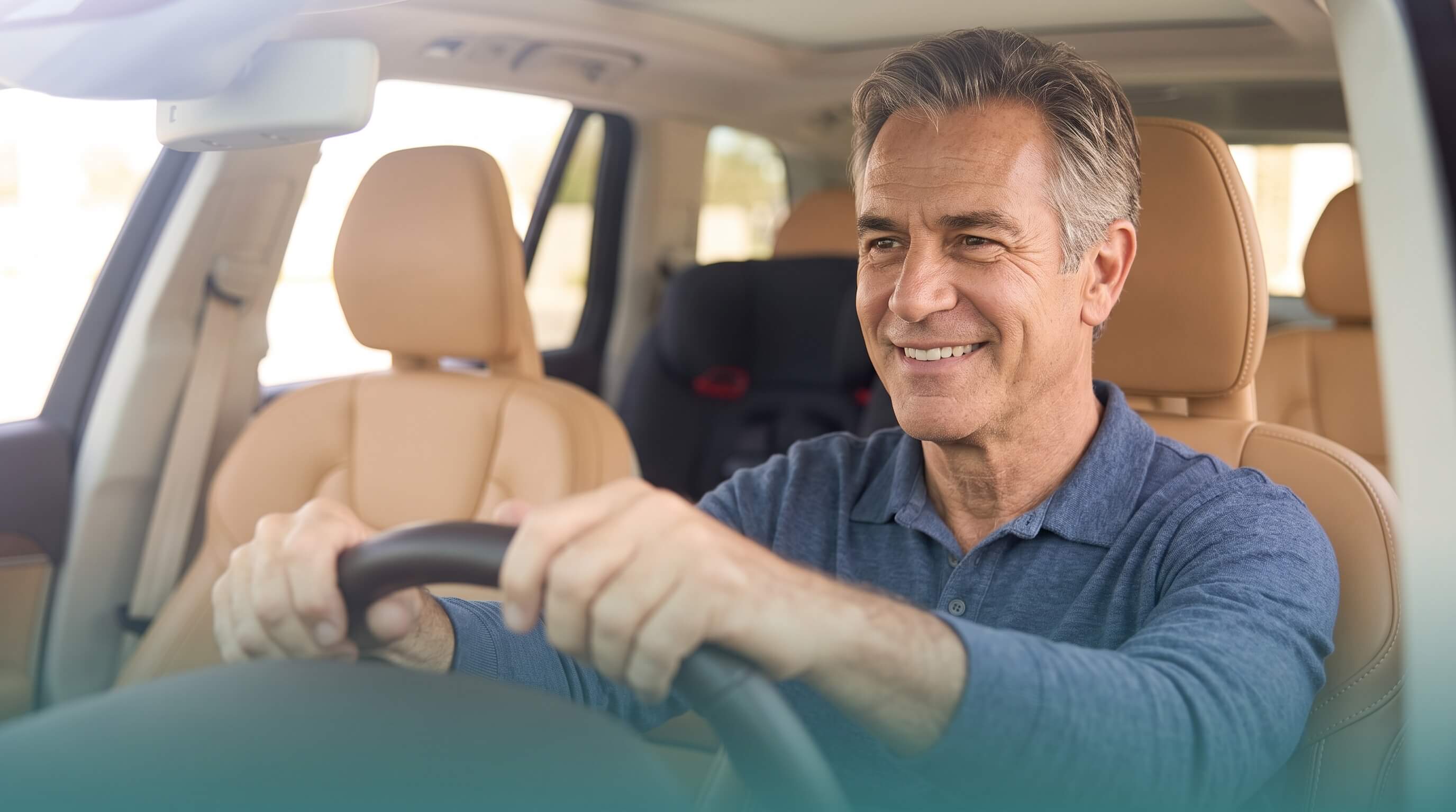 Senior driver smiling behind the wheel of a comfortable luxury vehicle